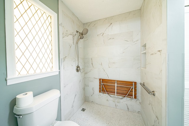 full bath with toilet, a marble finish shower, and a textured ceiling