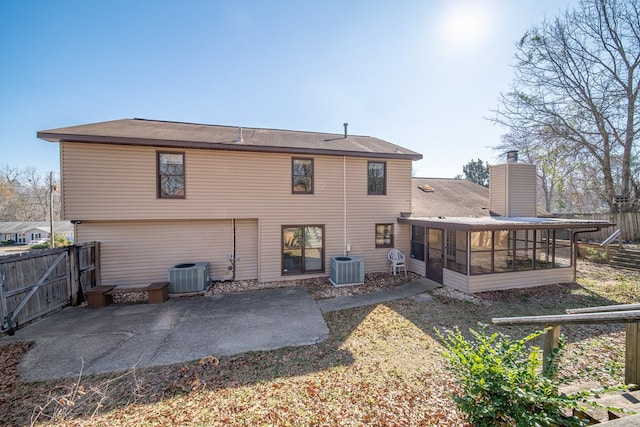 rear view of house with a sunroom, fence, central AC, and a patio