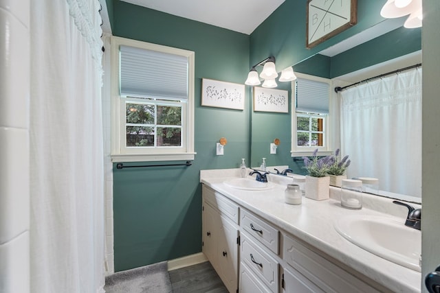 1903 Ashley Dr, Phenix City, AL 36867 - bathroom featuring double vanity, baseboards, a shower with shower curtain, and wood finished floors