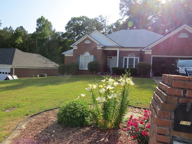 view of front of property featuring a garage, brick siding, and a front yard