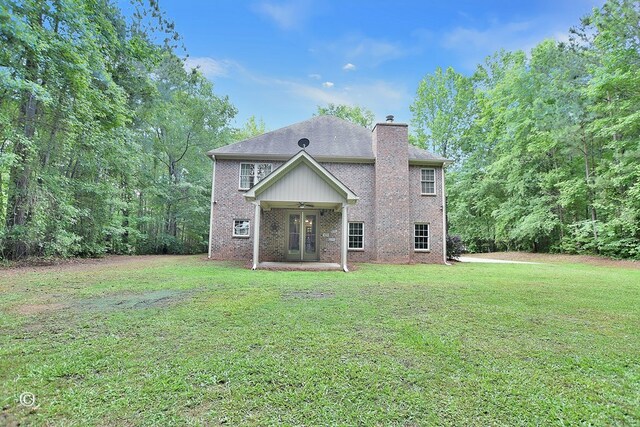 72W Teddy Bear Ln, Waverly Hall, GA 31831 - rear view of house featuring a ceiling fan, a lawn, a chimney, brick siding, and a patio area