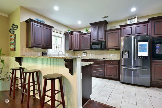 72W Teddy Bear Ln, Waverly Hall, GA 31831 - kitchen featuring black appliances, a breakfast bar, a peninsula, tasteful backsplash, and recessed lighting