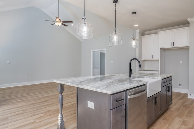 kitchen with stainless steel dishwasher, a kitchen island with sink, light stone countertops, and white cabinets