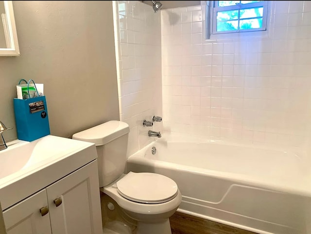 full bathroom featuring toilet, vanity, wood-type flooring, and tiled shower / bath