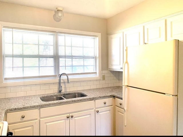 kitchen with white cabinets, sink, decorative backsplash, plenty of natural light, and white fridge