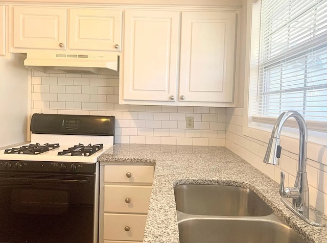 kitchen featuring white range with gas cooktop, decorative backsplash, and sink