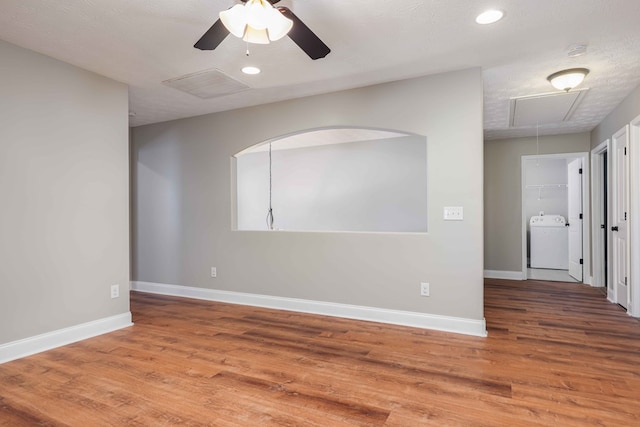 unfurnished room with hardwood / wood-style flooring, ceiling fan, a textured ceiling, and washer / dryer