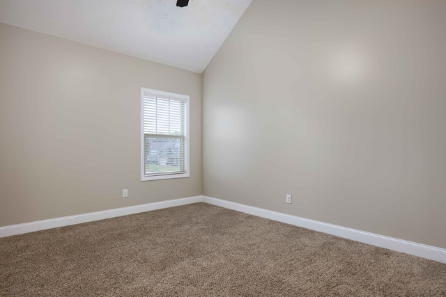 unfurnished room with a textured ceiling, carpet, and vaulted ceiling