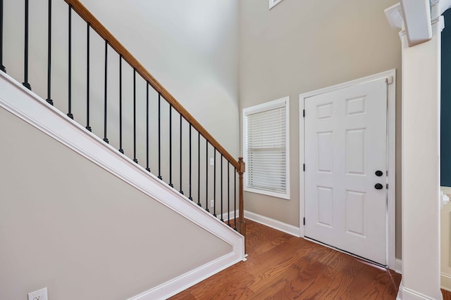 foyer entrance featuring hardwood / wood-style floors and a high ceiling