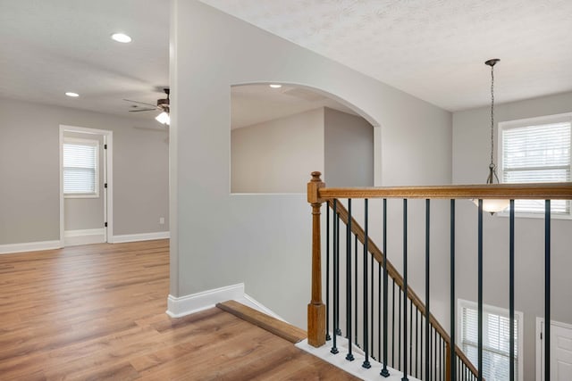 staircase with hardwood / wood-style floors, a textured ceiling, and a wealth of natural light