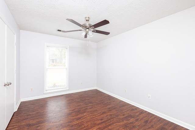 empty room featuring ceiling fan, dark hardwood / wood-style flooring, and a textured ceiling