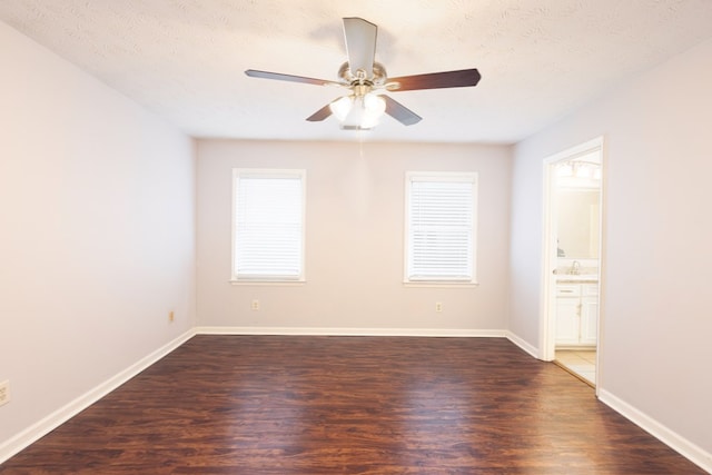 empty room with a textured ceiling, ceiling fan, and dark wood-type flooring