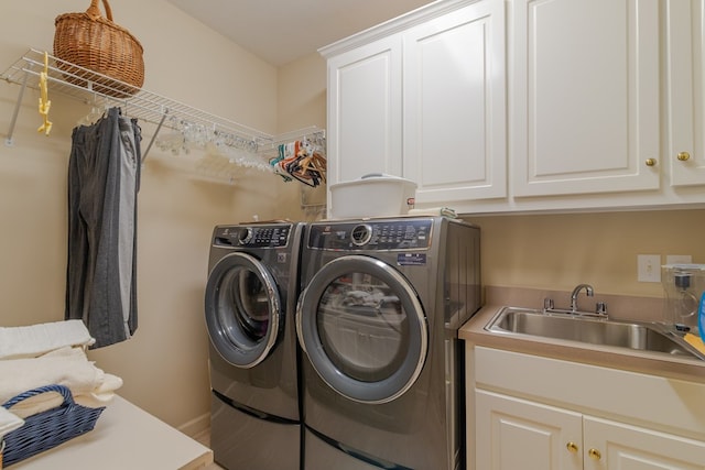 washroom with washer and dryer, cabinet space, and a sink