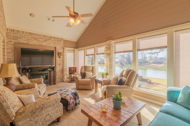 sunroom / solarium featuring a water view, ceiling fan, visible vents, and vaulted ceiling