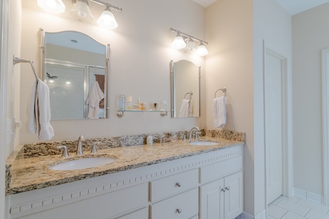 bathroom featuring double vanity, an enclosed shower, a sink, and tile patterned floors