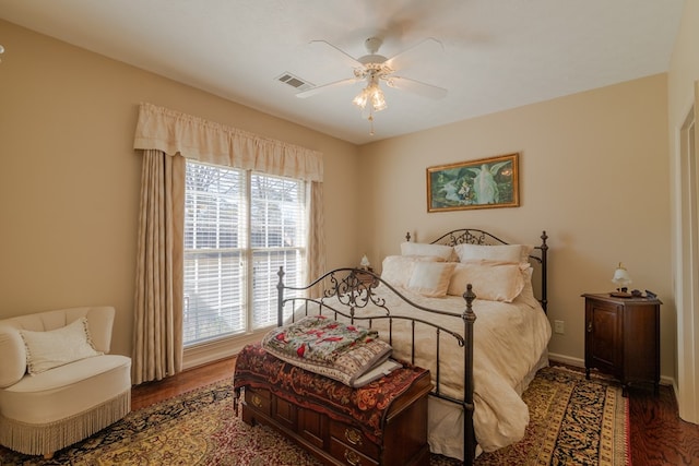 bedroom with a ceiling fan, baseboards, visible vents, and wood finished floors