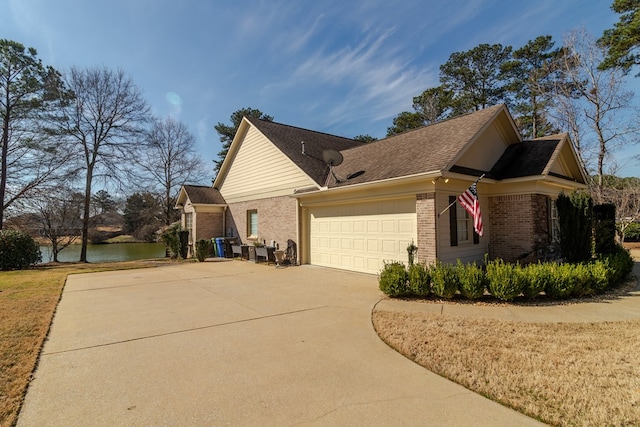 view of side of property with driveway, an attached garage, and brick siding