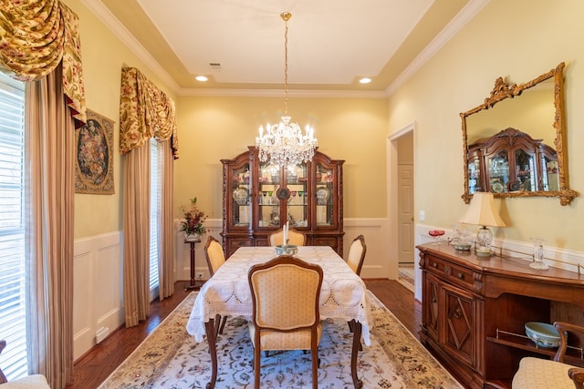 dining area with a chandelier, wainscoting, and wood finished floors