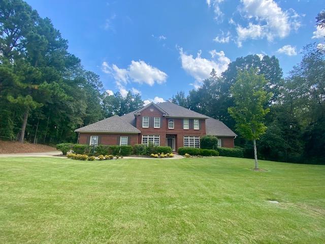 colonial-style house with a front lawn