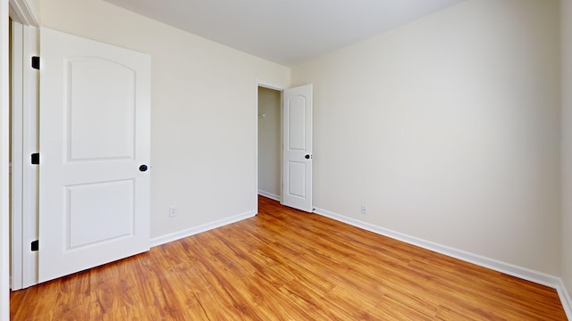 unfurnished bedroom featuring baseboards and light wood finished floors