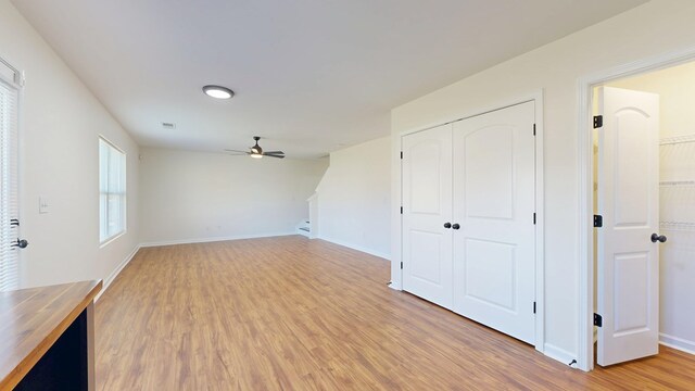 unfurnished living room featuring light wood-style flooring, visible vents, baseboards, and ceiling fan