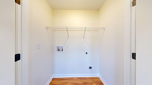 clothes washing area featuring hookup for a washing machine, hookup for an electric dryer, baseboards, and wood finished floors