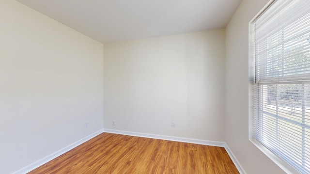 spare room featuring light wood-style flooring and baseboards