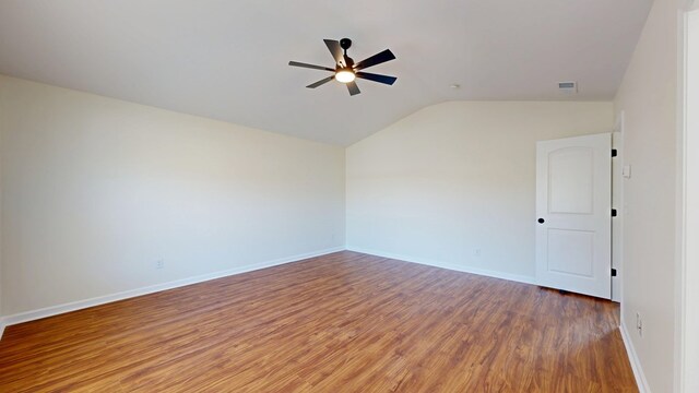 spare room with visible vents, baseboards, vaulted ceiling, wood finished floors, and a ceiling fan