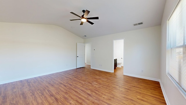 unfurnished room featuring light wood-type flooring, visible vents, a ceiling fan, baseboards, and lofted ceiling