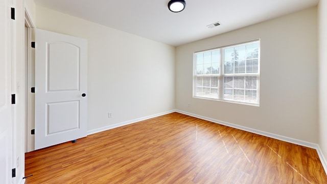 spare room with visible vents, baseboards, and light wood-style floors