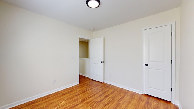 unfurnished bedroom with baseboards and light wood-style flooring