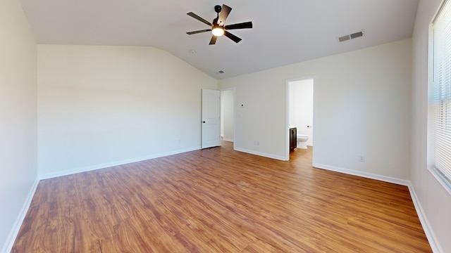 unfurnished room featuring lofted ceiling, light wood-style floors, visible vents, and baseboards