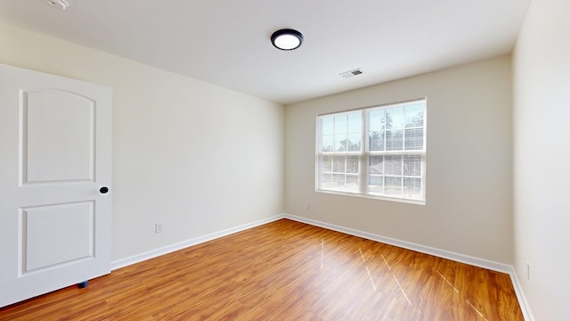 empty room featuring visible vents, baseboards, and light wood-style floors