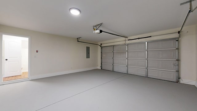 garage with electric panel, a garage door opener, and baseboards