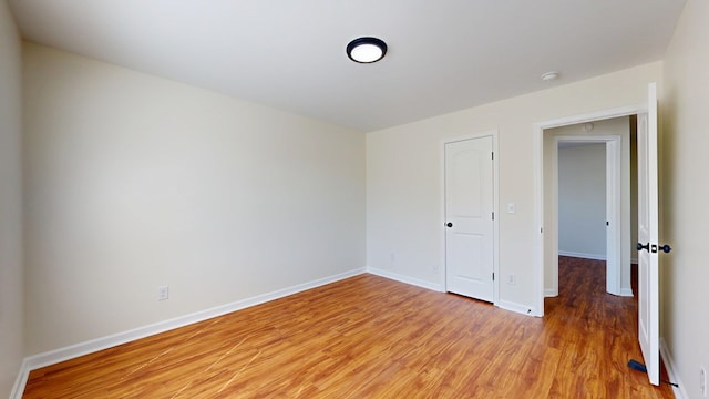 empty room featuring light wood-style floors and baseboards