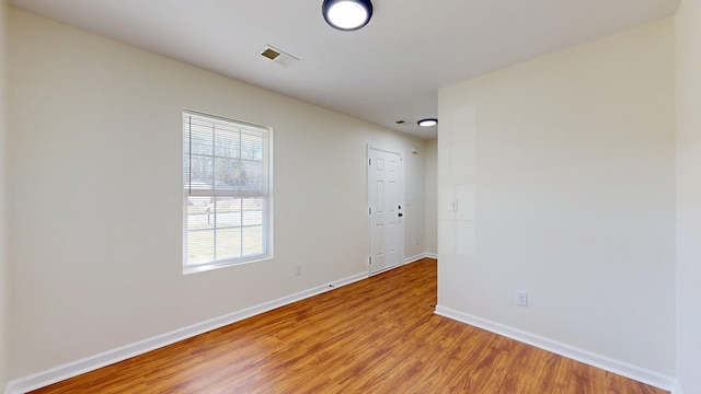 unfurnished room with light wood-type flooring, baseboards, and visible vents