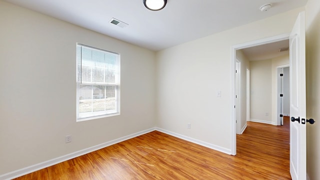 empty room with visible vents, baseboards, and light wood-type flooring