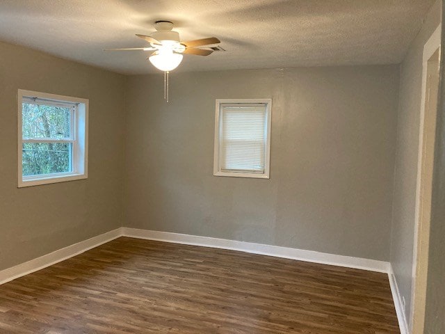 spare room with a textured ceiling, ceiling fan, and dark hardwood / wood-style floors