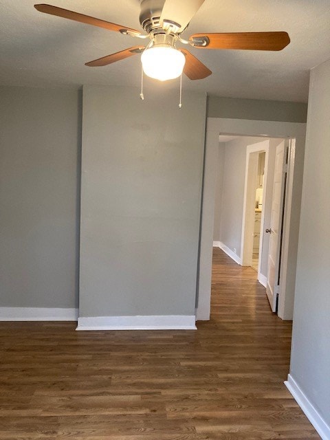 unfurnished room with dark hardwood / wood-style floors and ceiling fan