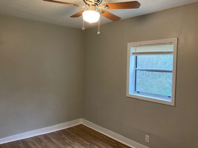 unfurnished room featuring ceiling fan and dark wood-type flooring