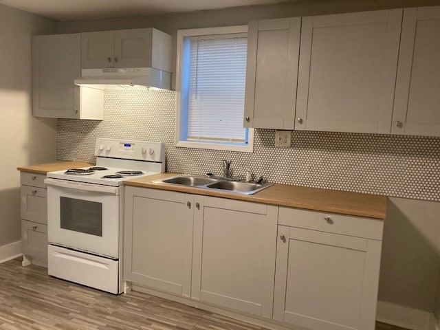 kitchen with white range with electric cooktop, ventilation hood, sink, tasteful backsplash, and white cabinetry