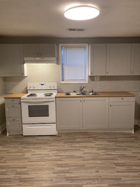 kitchen featuring butcher block countertops, white range with electric cooktop, sink, and light hardwood / wood-style flooring