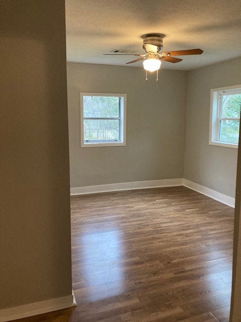 spare room with ceiling fan and dark wood-type flooring