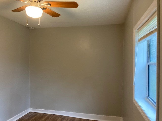 empty room with ceiling fan and dark wood-type flooring