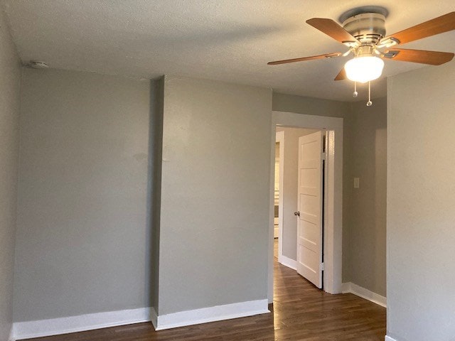 spare room with ceiling fan and dark hardwood / wood-style flooring