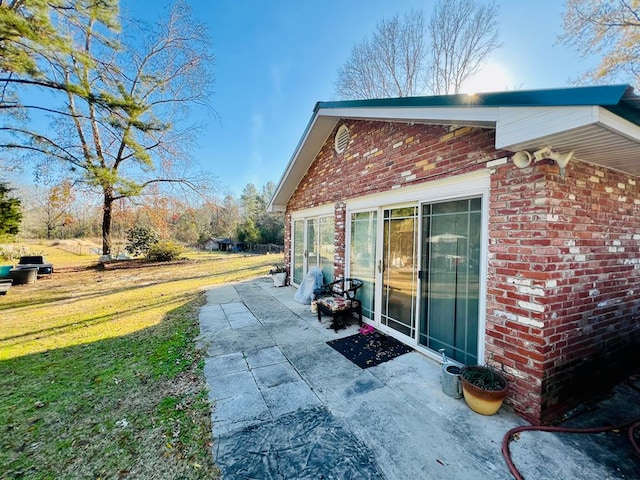 view of home's exterior with a patio and a lawn