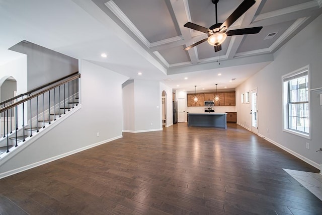 unfurnished living room with arched walkways, dark wood-style flooring, stairway, coffered ceiling, and baseboards