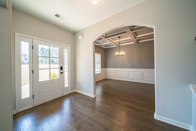 entryway featuring arched walkways, beam ceiling, visible vents, dark wood-type flooring, and coffered ceiling