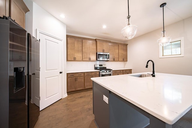 kitchen featuring appliances with stainless steel finishes, dark wood-style flooring, hanging light fixtures, a sink, and recessed lighting