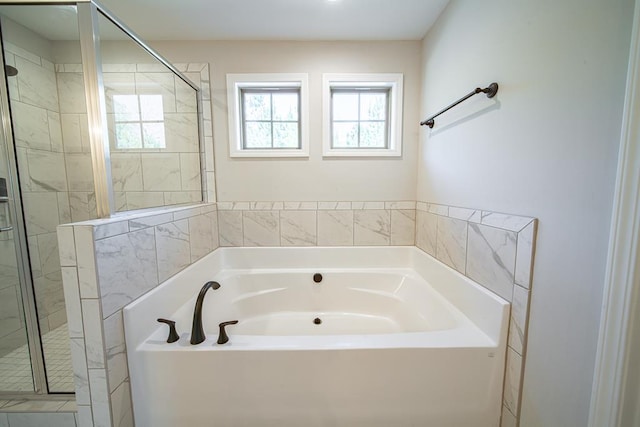 full bath with a stall shower and a garden tub